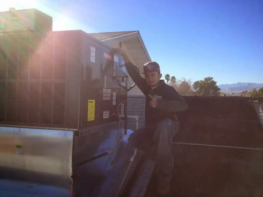 HVAC technician performing AC Tune-Up on a rooftop unit in Northgate