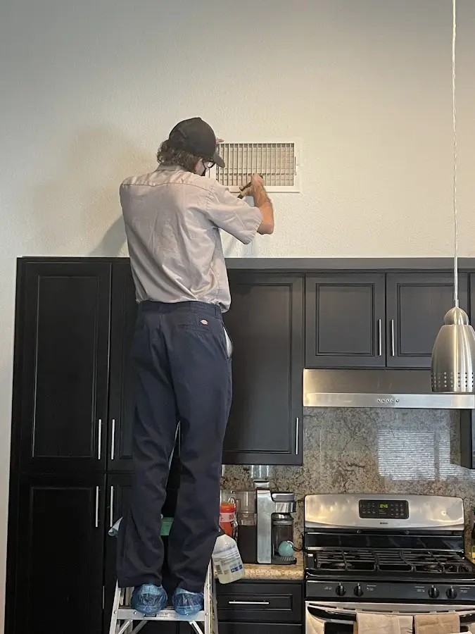 Technician inspecting an air vent during HVAC service in Northgate